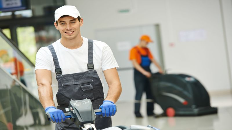 21766362_l-Cleaner-male-man-workers-with-mop-in-uniform-cleaning-corridor-pass-or-hall-floor-of-business-building.jpg